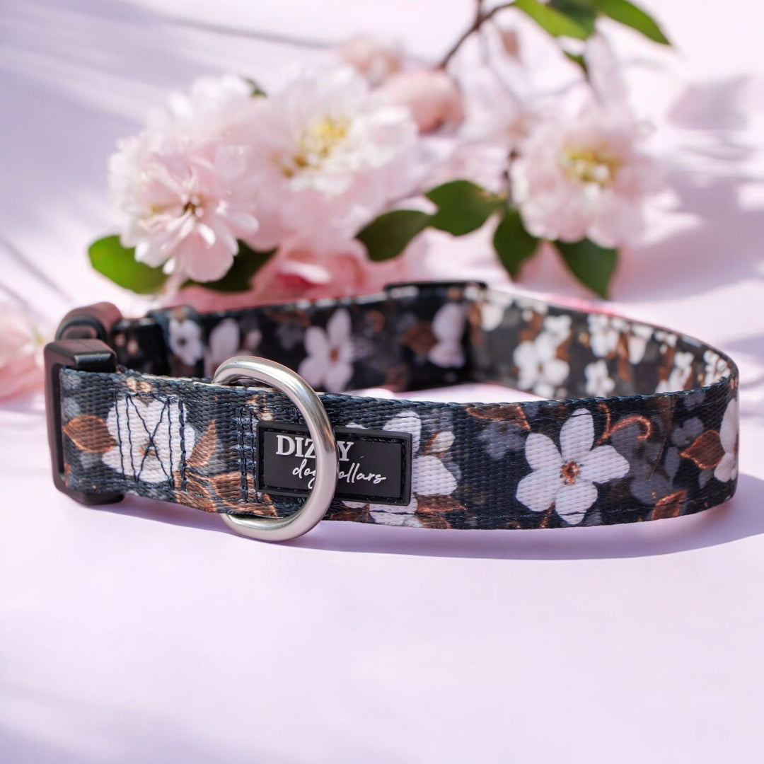 Floral-patterned dog collar with 'Dizzy Dog Collars' brand on a light background with flowers.