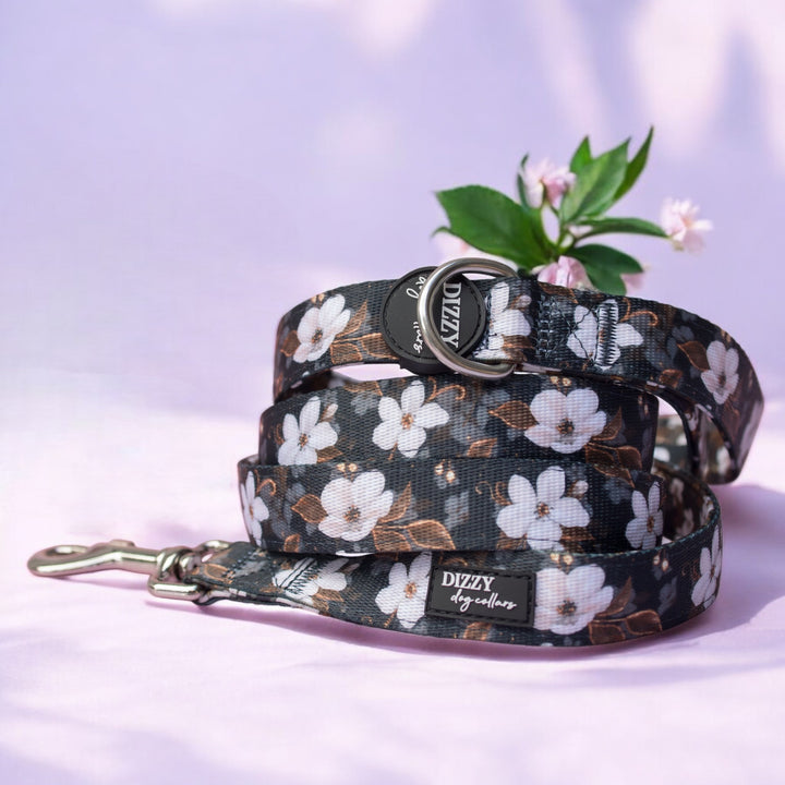 Floral-patterned dog leash with brand name on a light purple background