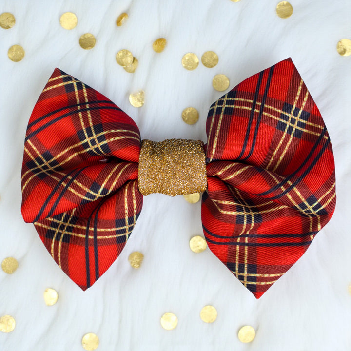 Red plaid bow with gold center on a white background with gold polka dots