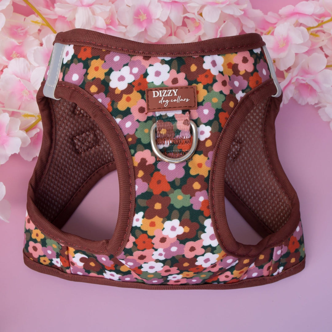 Floral patterned dog harness with brown trim on a pink floral background