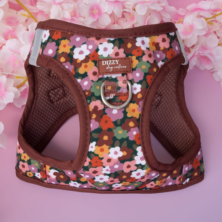 Floral patterned dog harness with brown trim on a pink floral background