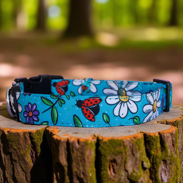 Dog collar with floral and insect pattern on a wooden stump outdoors