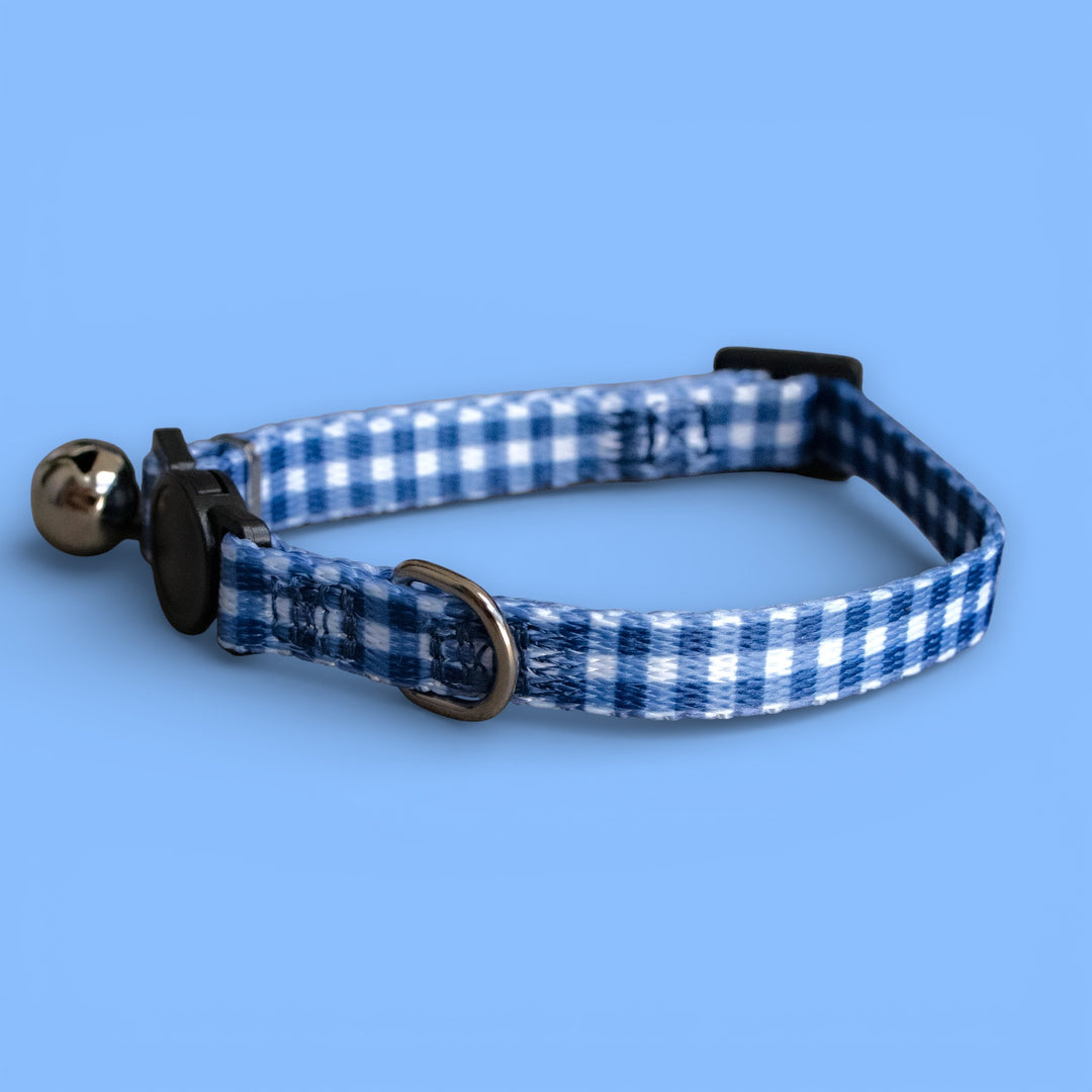 Blue and white checkered cat collar with bell on a blue background