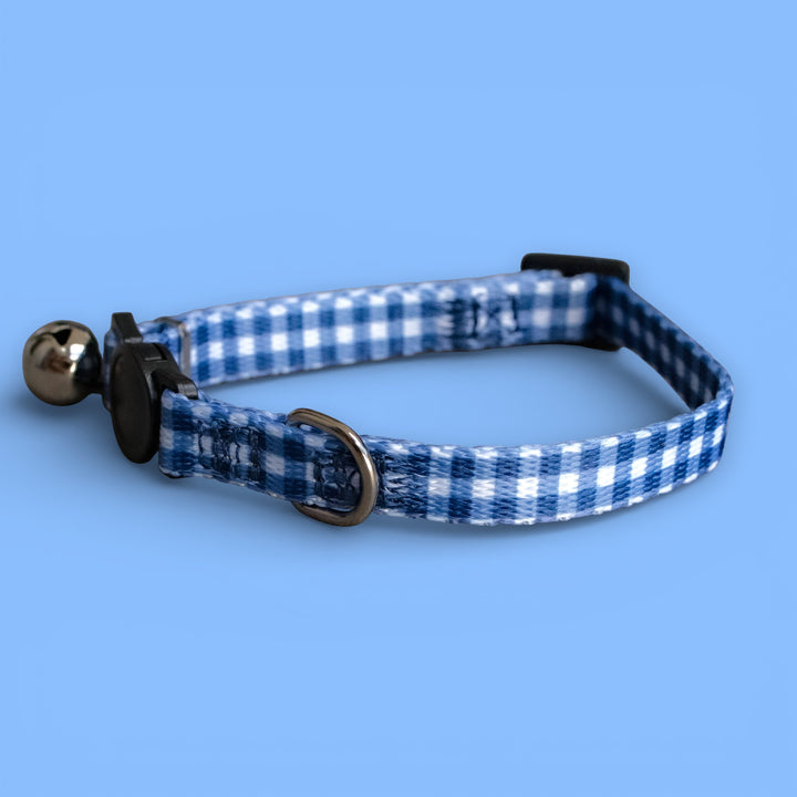 Blue and white checkered cat collar with bell on a blue background